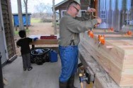 Off-Grid Undertaker Don Byrne works on a hand-made pine coffin in his outdoor studio on a 32-acre homestead in Bear Creek, N.C. Byrne lives off the grid, with no electricity and running water. In the background is his son, Niko, 4. He builds the coffins with antique hand tools, selling them for about $875 to $1,000 to people who want a simple, ``green'' burial.