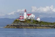 Red and white C19th lighthouse on island in Maine