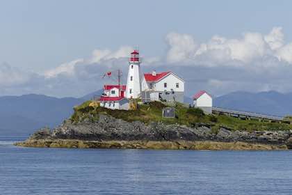 Red and white C19th lighthouse on island in Maine